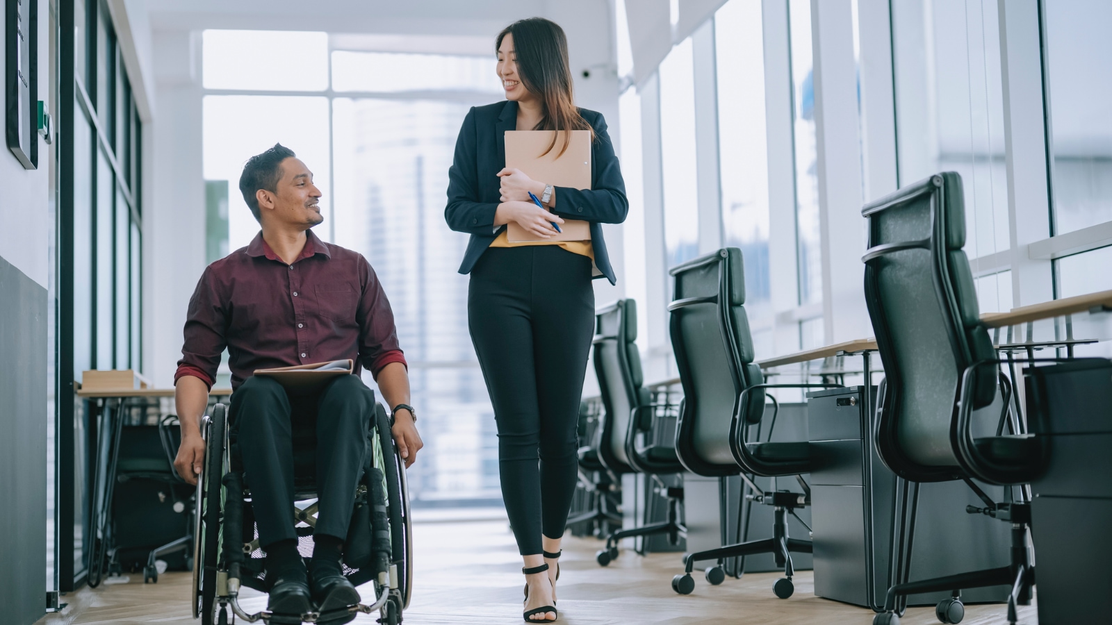 man in wheelchair talking to woman beside him